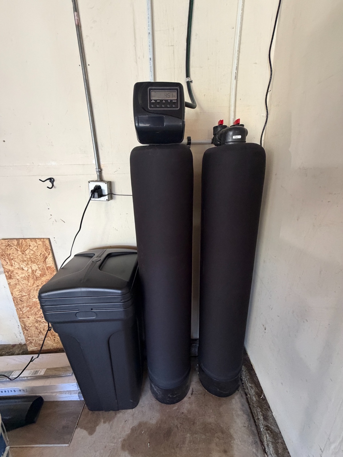 Dual-tank whole-home filtration and softening equipment installed inside a Citrus Heights garage.