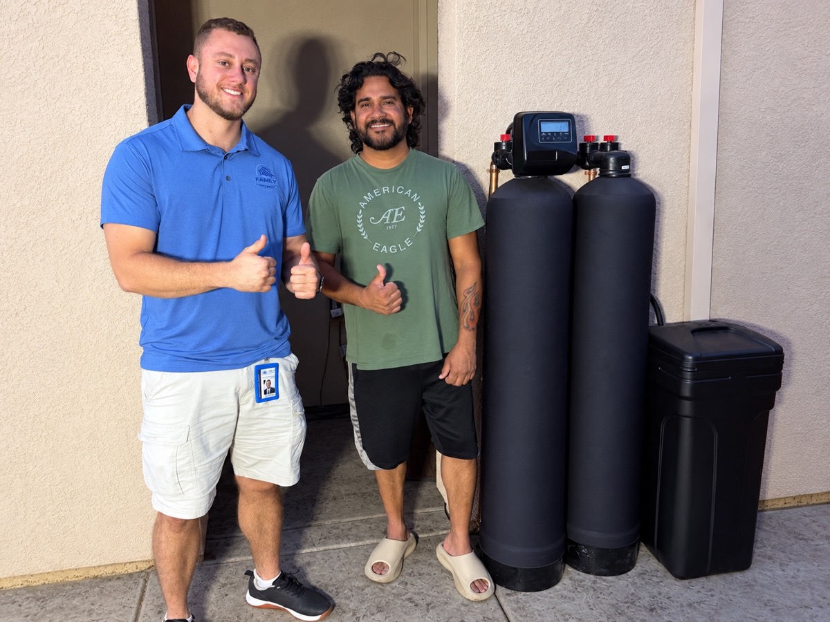 Family First Water team member and Rancho Cordova homeowner beside a completed whole-home filtration and softening installation